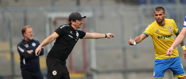 Cheftrainer Daniel Meyer (Eintracht Braunschweig) reicht waehrend des Spieles einen Zettel an Robin Ziegele (Eintracht